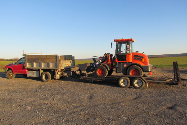 Wheel loader 1650 on trailer with dump truck